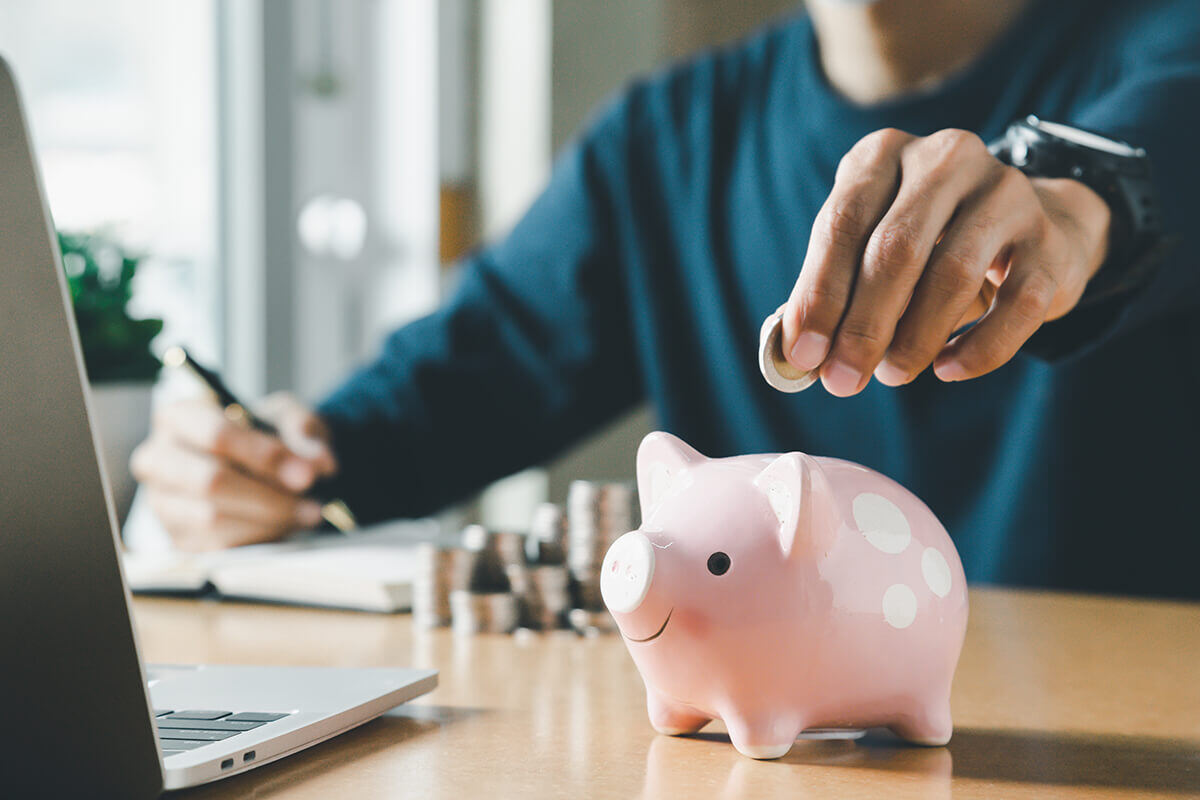 tirelire-cochon-piece-monnaie-euro-argent-bureau-ordinateur-main-homme